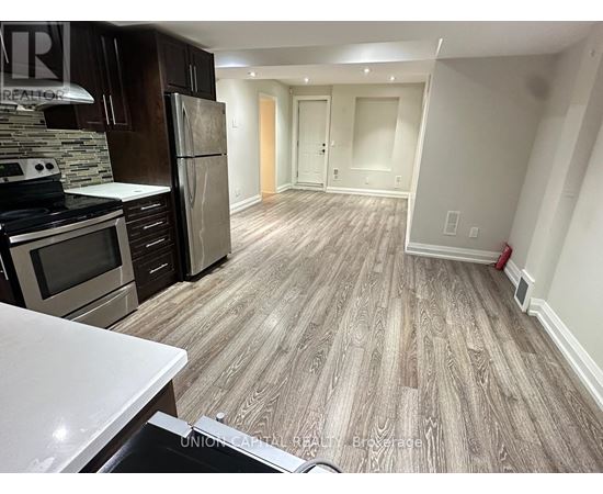 A kitchen with wooden flooring and a white counter top.