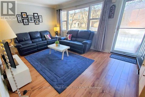 A living room with a blue rug and a white coffee table.