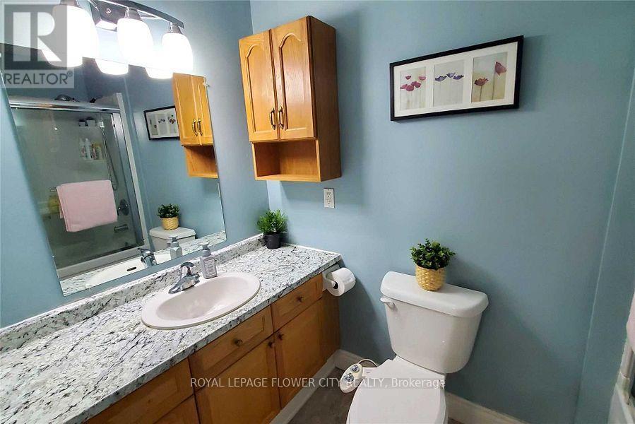 A bathroom with a sink, toilet and a mirror.