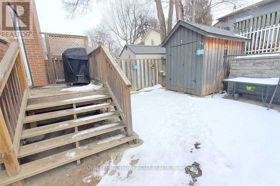 A backyard with a wooden deck and a shed.