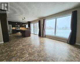 A spacious room with a large window and a view of a fence.