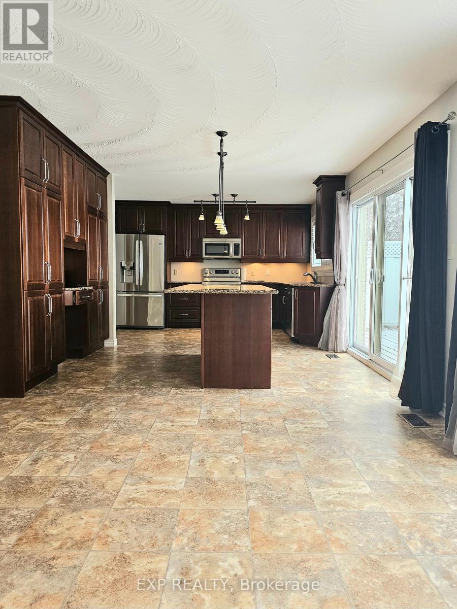 A kitchen with brown cabinets and a tiled floor.