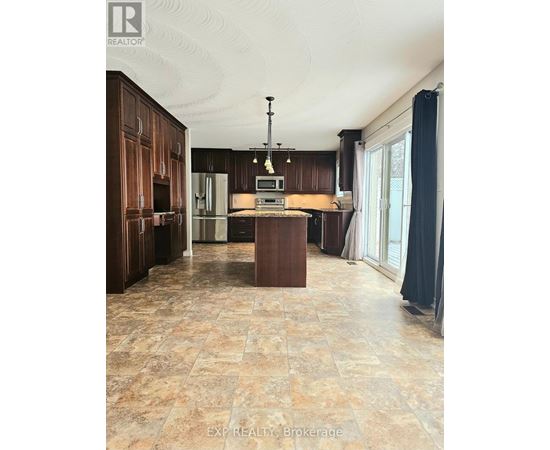 A kitchen with brown cabinets and a tiled floor.