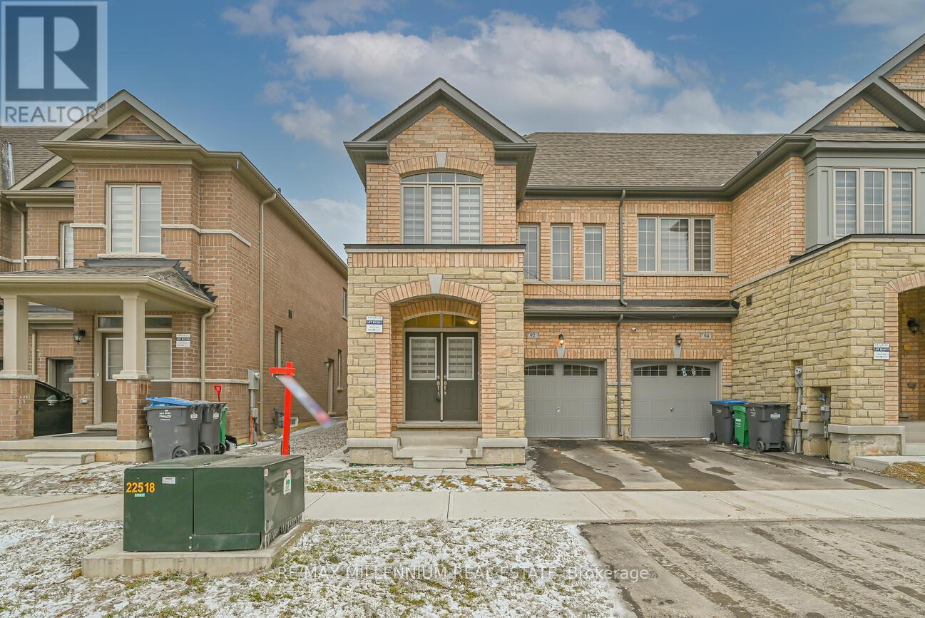 A large brick house with a garage and a driveway in front.