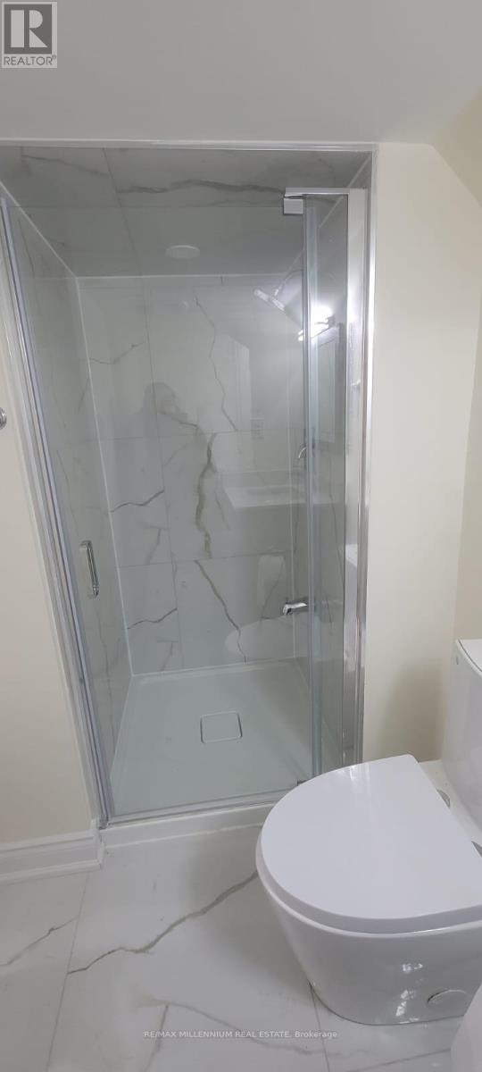 A white toilet in a bathroom with a glass shower door.