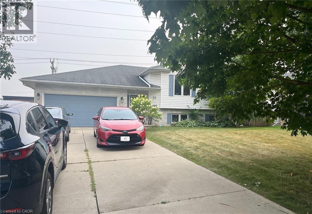 A red car is parked in front of a house.