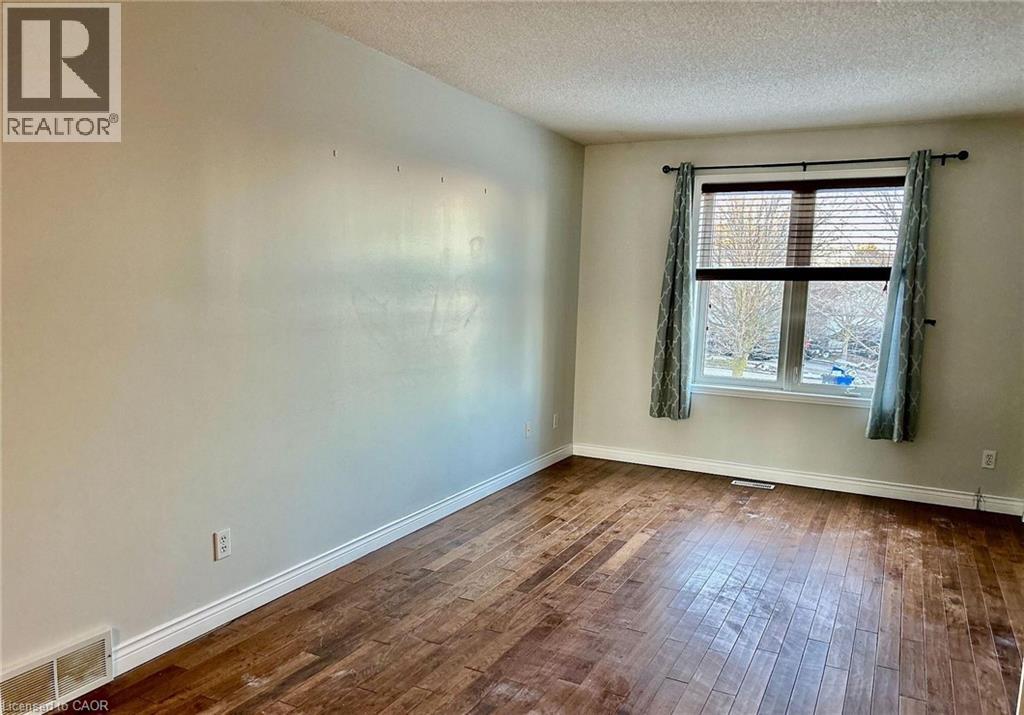A room with wooden floors and a window with curtains.