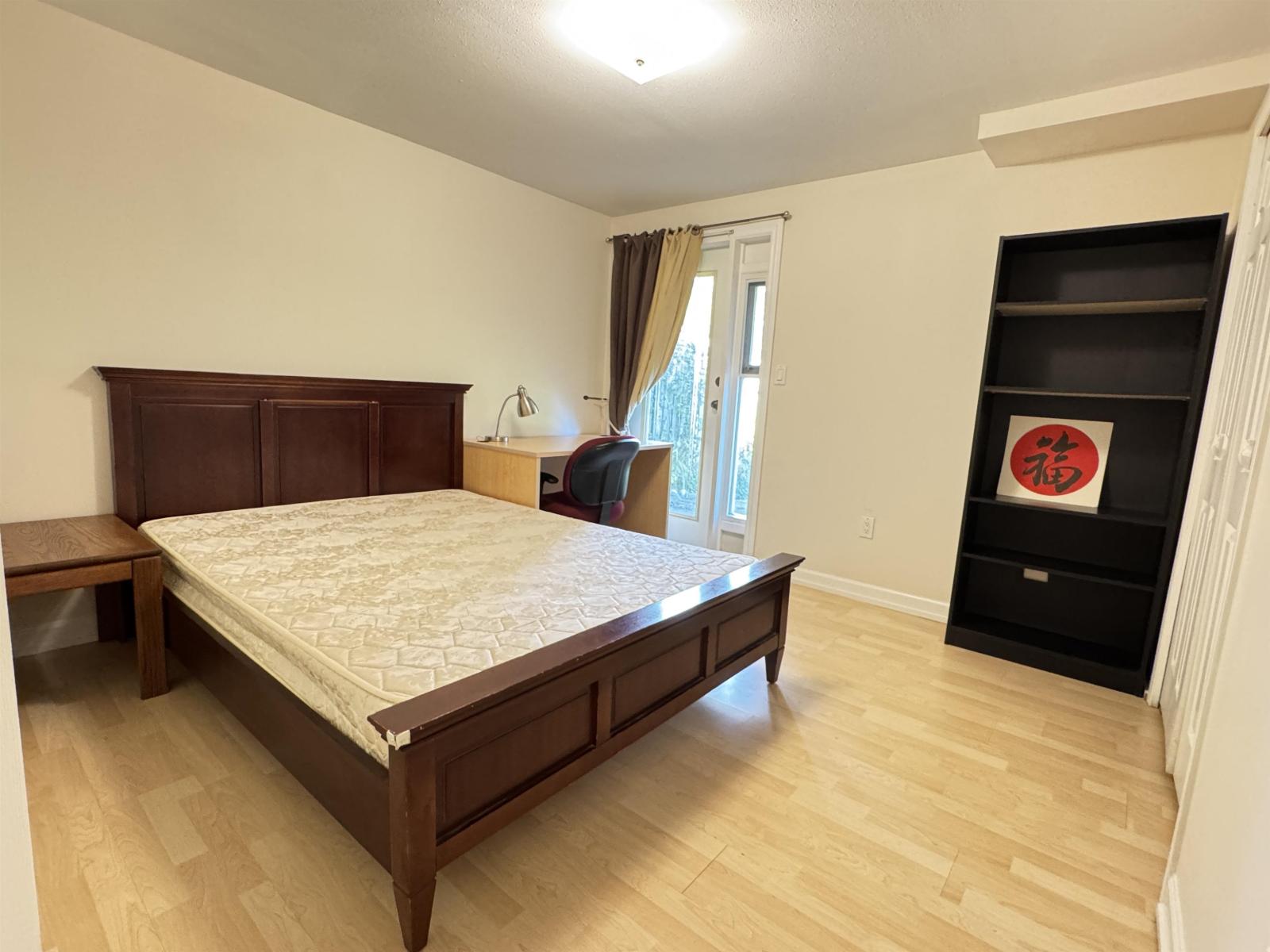 A bedroom with a large bed and a wooden headboard.