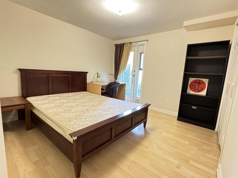 A bedroom with a large bed and a wooden headboard.