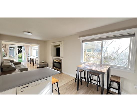 A kitchen with a dining table and chairs is shown.