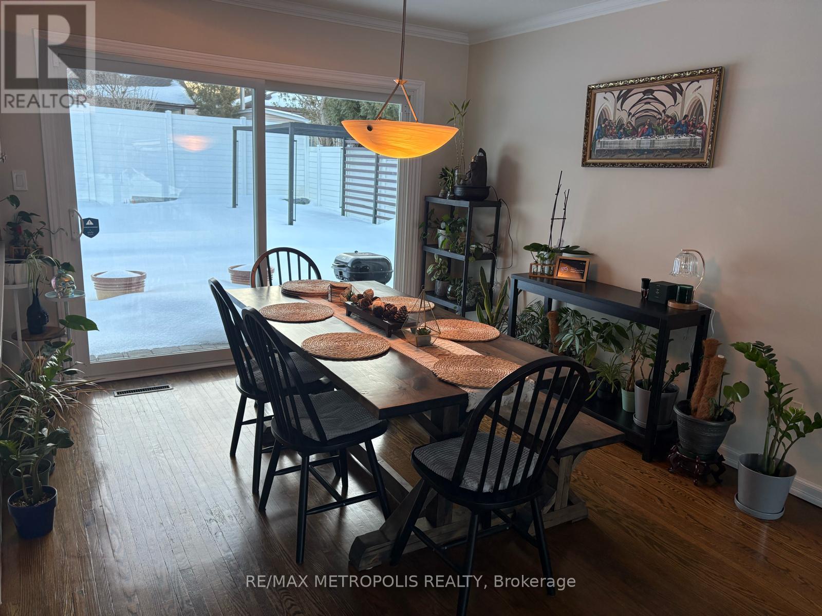 A dining room with a table set for six with a view of the backyard.