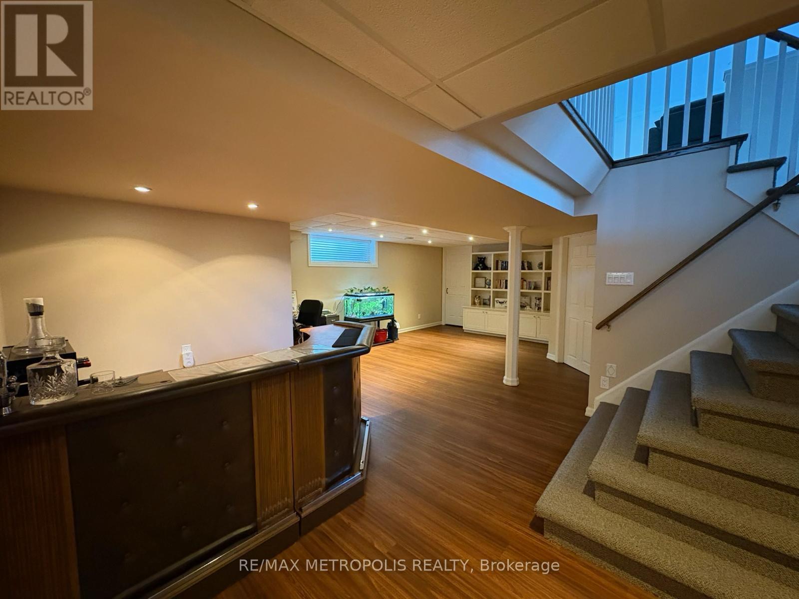 A spacious room with a staircase leading to the upper floor.