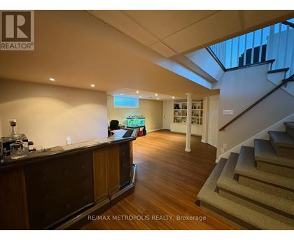A spacious room with a staircase leading to the upper floor.