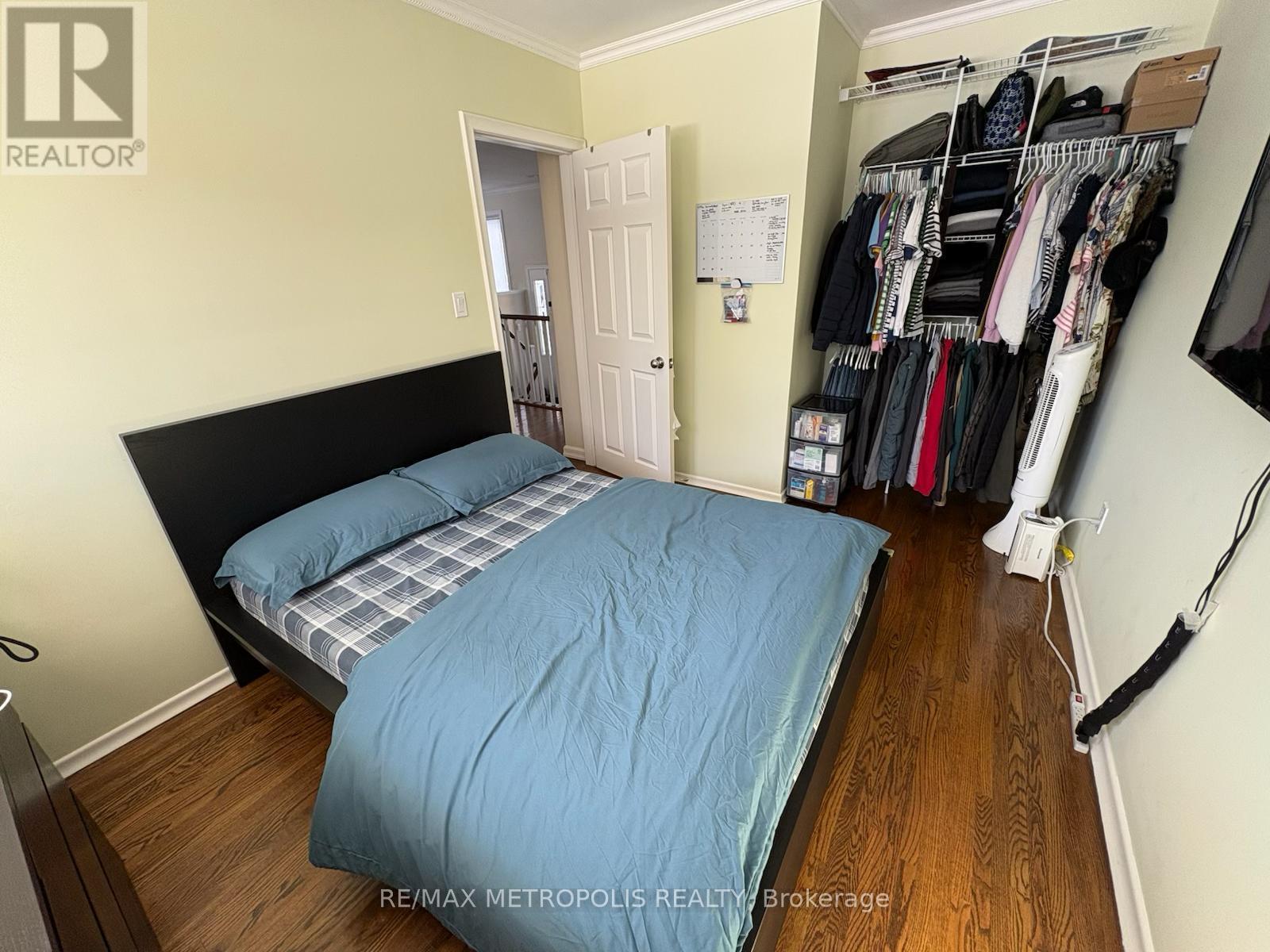 A bedroom with two beds and a closet full of clothes.