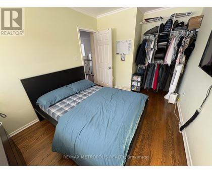 A bedroom with two beds and a closet full of clothes.