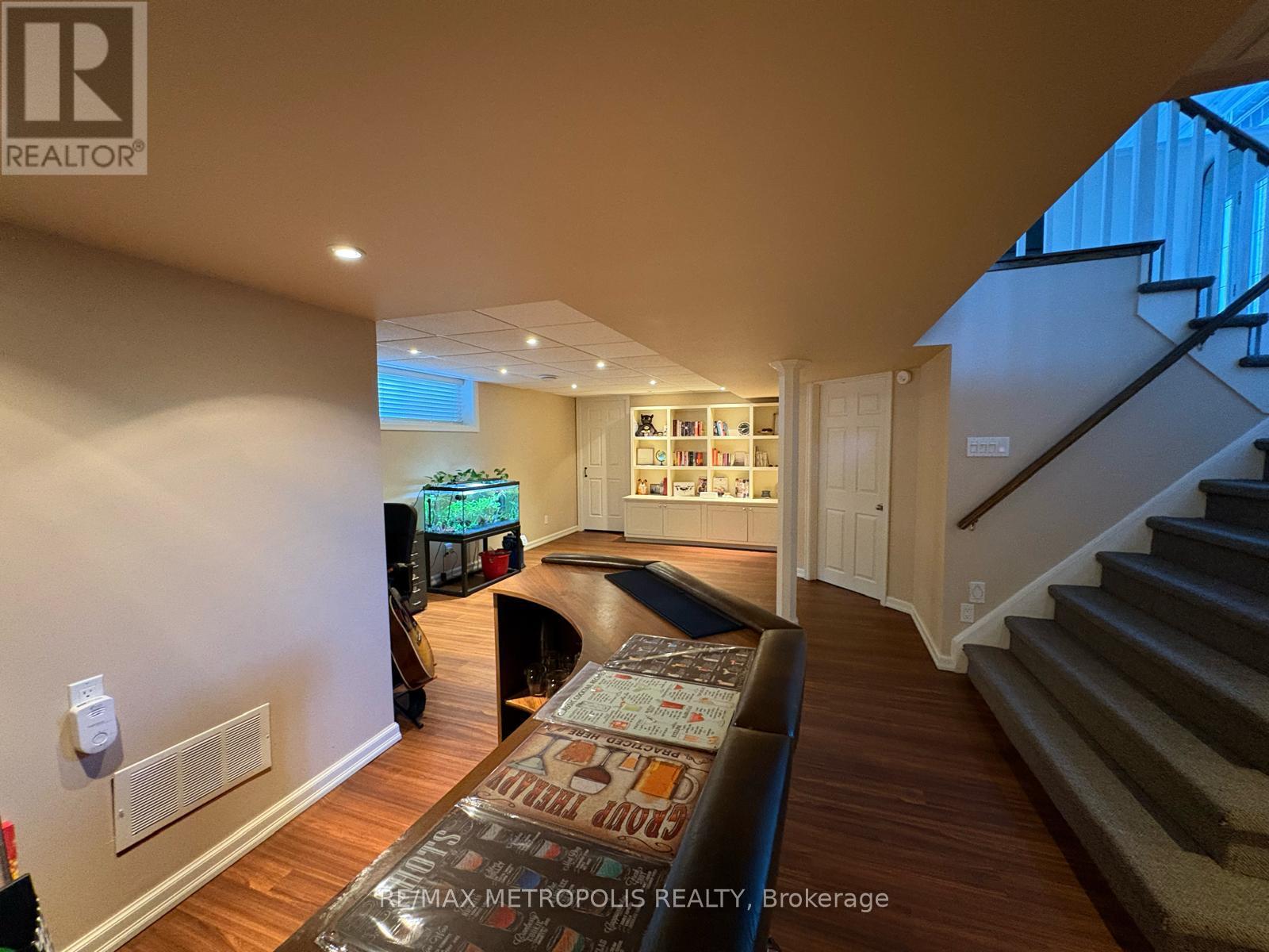 A living room with a couch and a staircase.