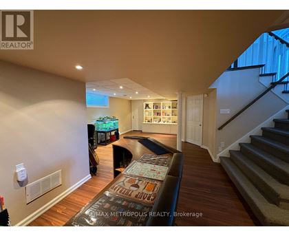 A living room with a couch and a staircase.