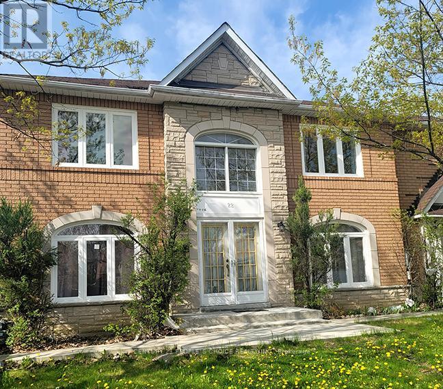 A house with a grey door and windows surrounded by greenery.