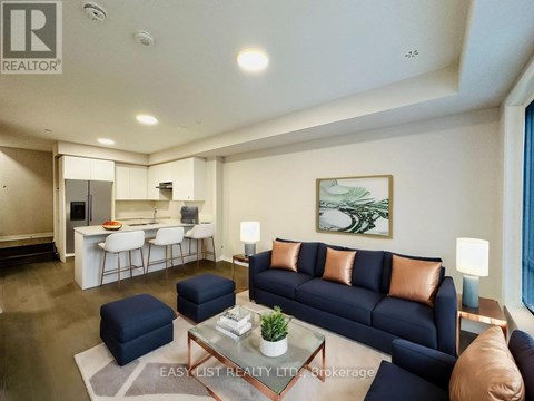 A living room with a dark blue sofa and a glass coffee table.