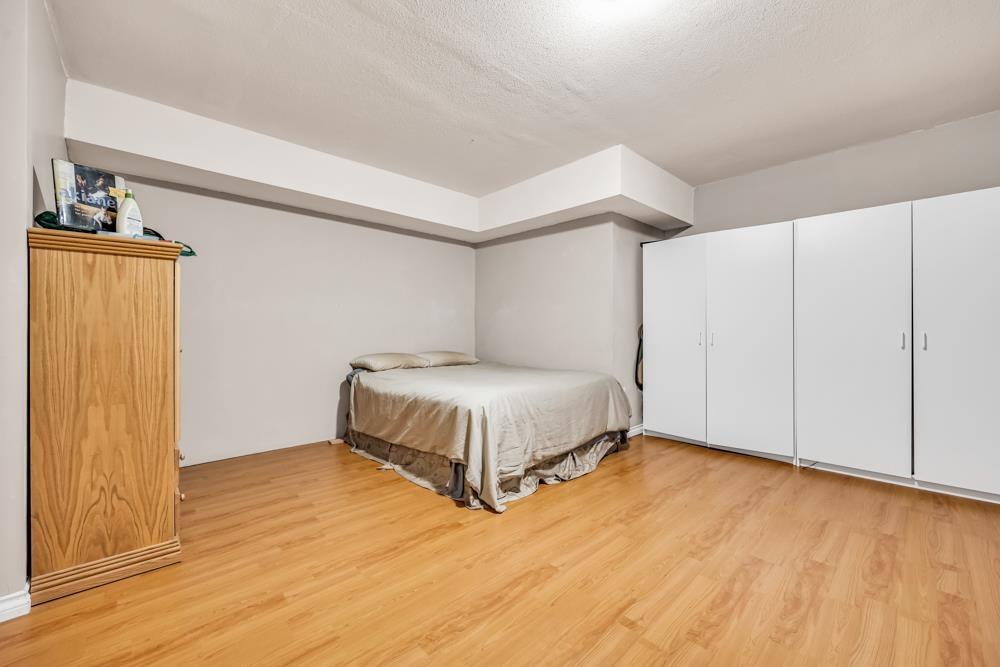 A bedroom with a bed, dresser, and wardrobe.