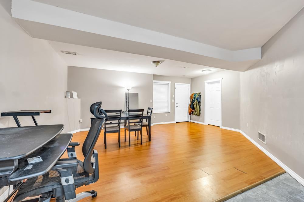 A room with a wooden floor and a table with chairs.