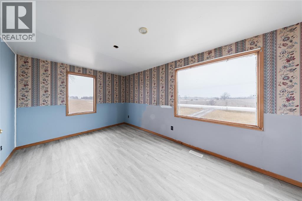 A room with a window and a wallpapered wall.