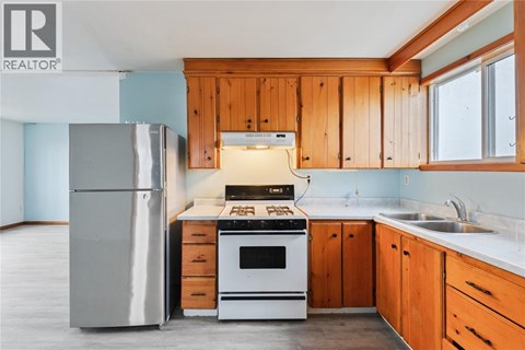 A kitchen with wooden cabinets and a white stove top oven.