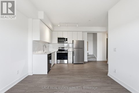 A modern kitchen with white cabinets and stainless steel appliances.