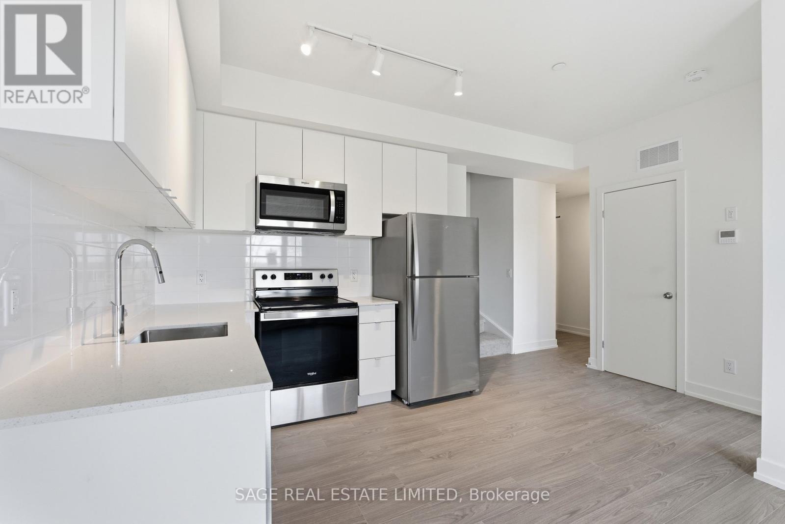 A modern kitchen with stainless steel appliances and a white countertop.