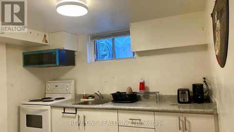 A kitchen with a microwave, oven, and sink.