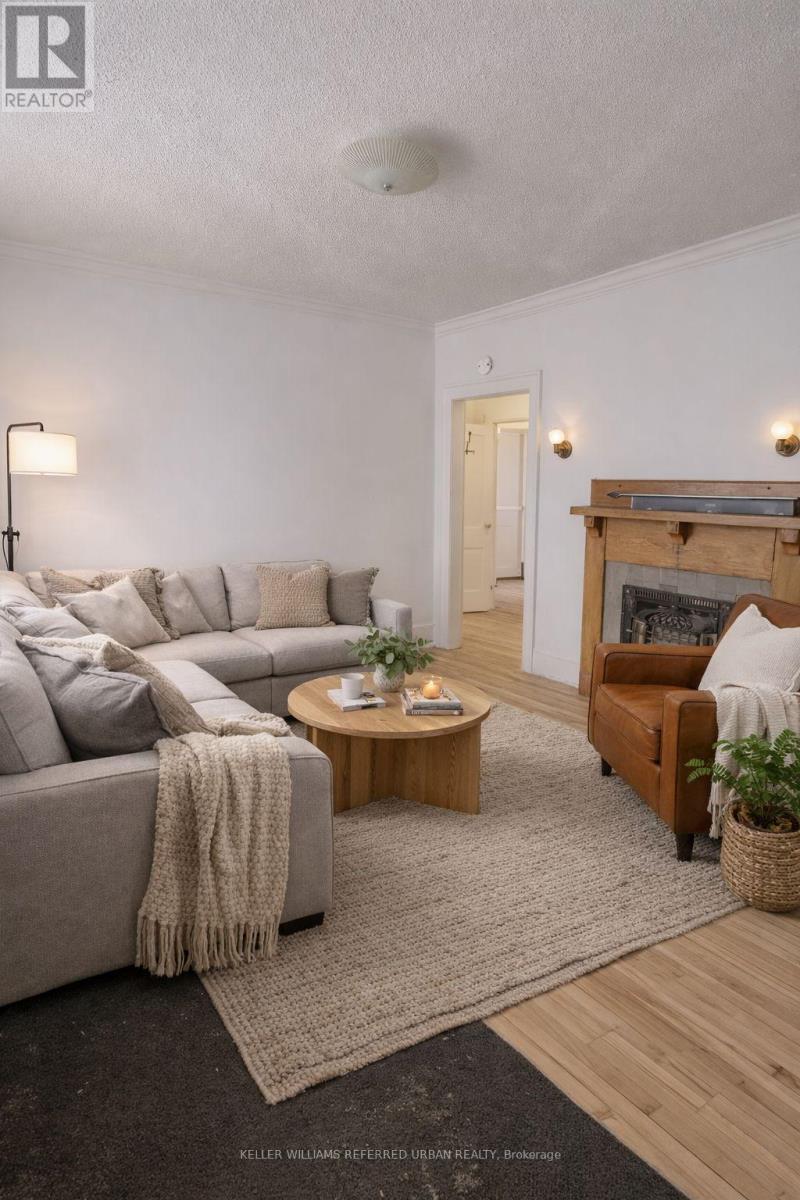 A living room with a grey couch, a wooden coffee table, a fireplace, and a rug.