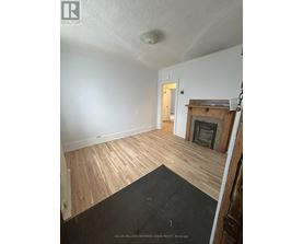 A room with a fireplace and wood flooring.