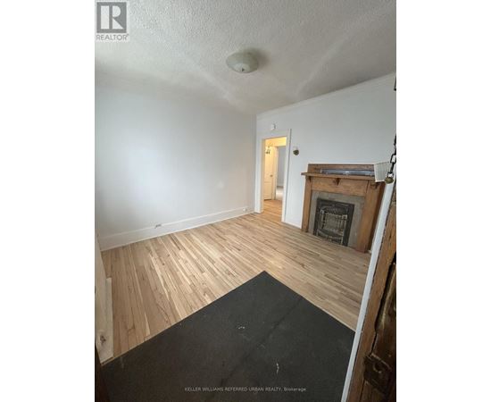 A room with a fireplace and wood flooring.