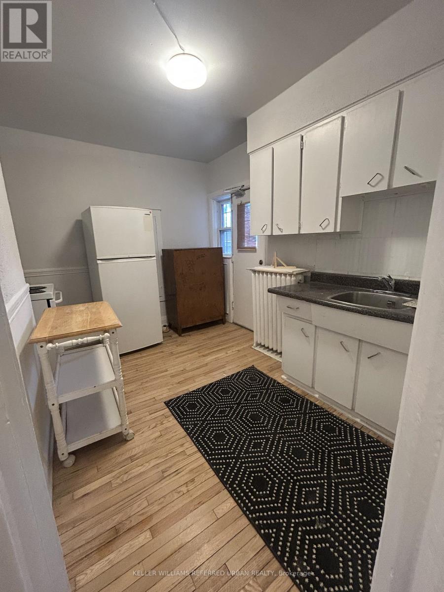 A kitchen with white cabinets and a black and white rug on the floor.