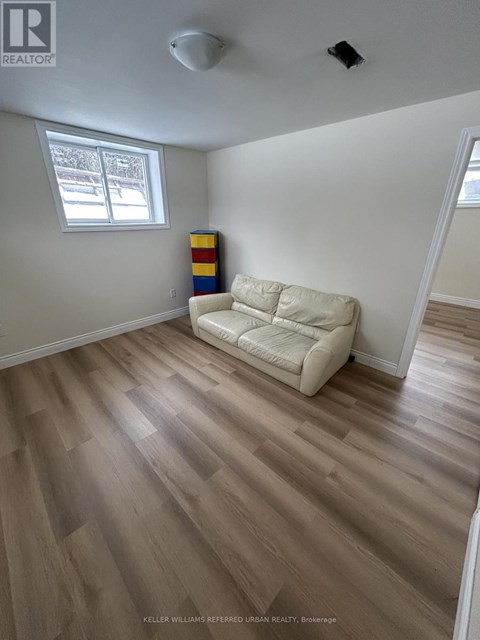 A living room with a white couch and wooden flooring.