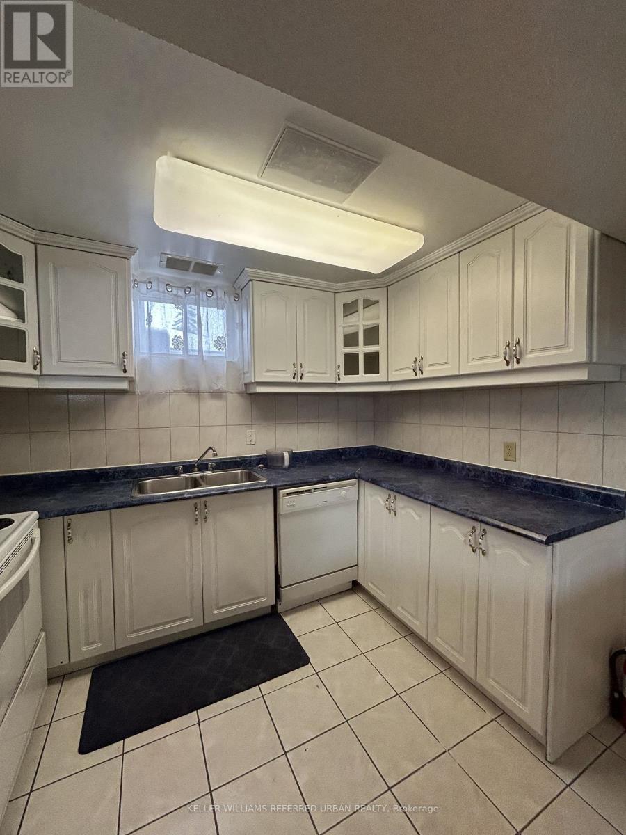 A kitchen with white cabinets and a black counter top.