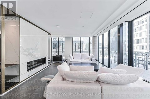 A modern living room with a white sofa and a fireplace.
