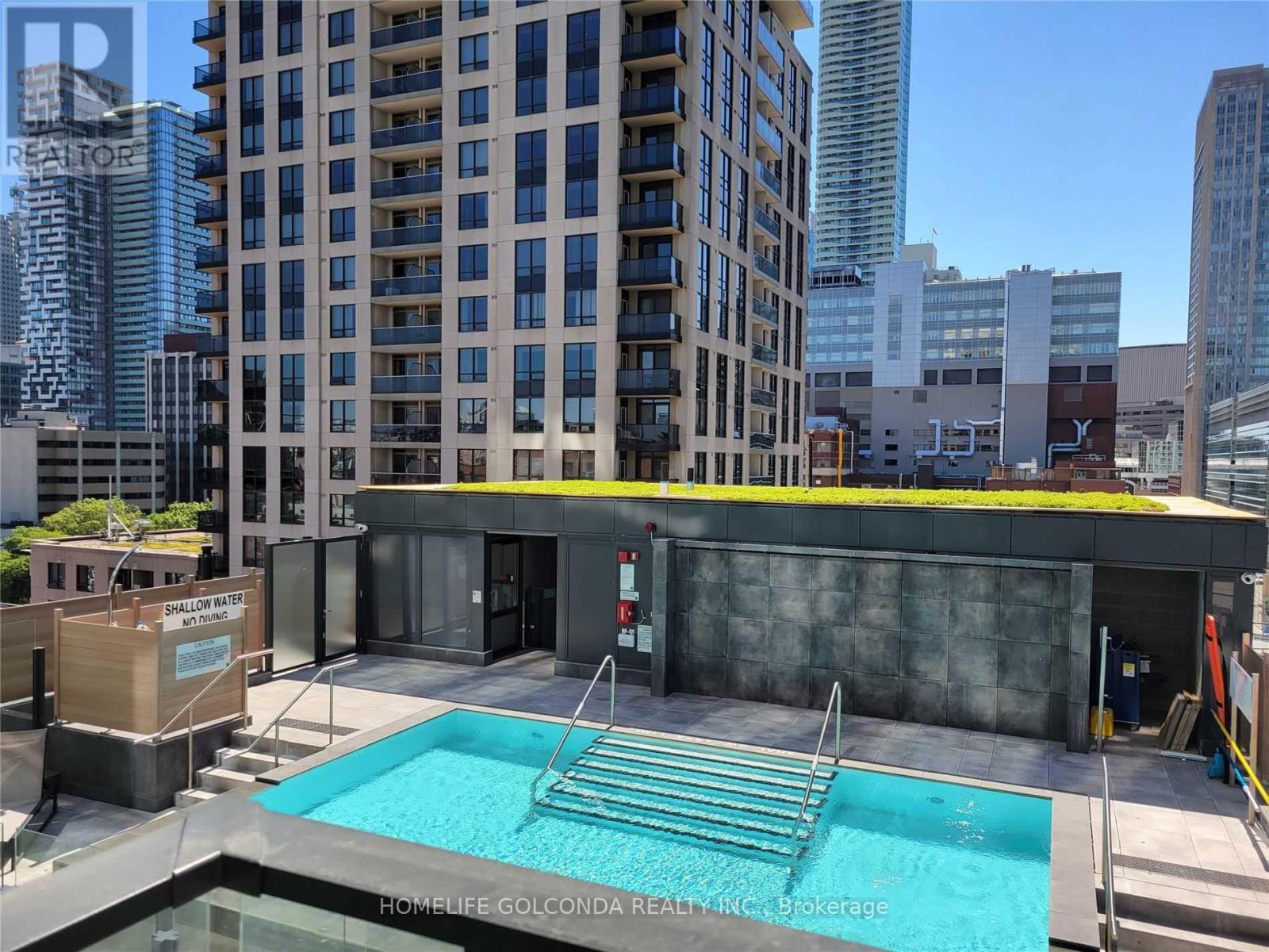 A pool in a courtyard surrounded by buildings.