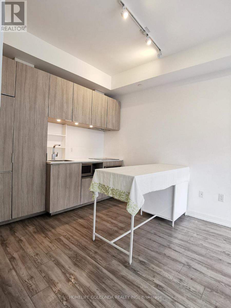 A kitchen with wooden cabinets and a table with a white cloth on it.