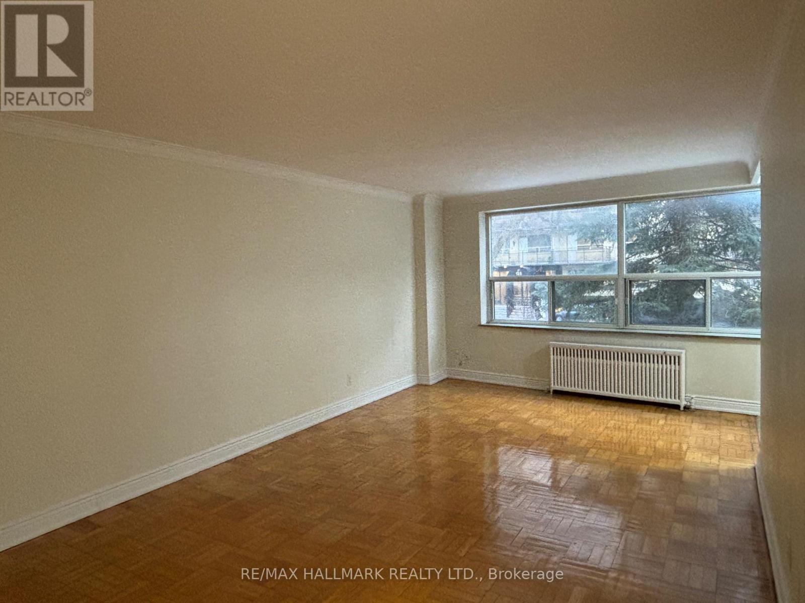 A room with a window and a radiator on the floor.