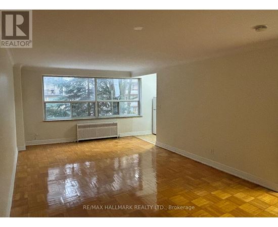 A room with a large window and a radiator on the wall.
