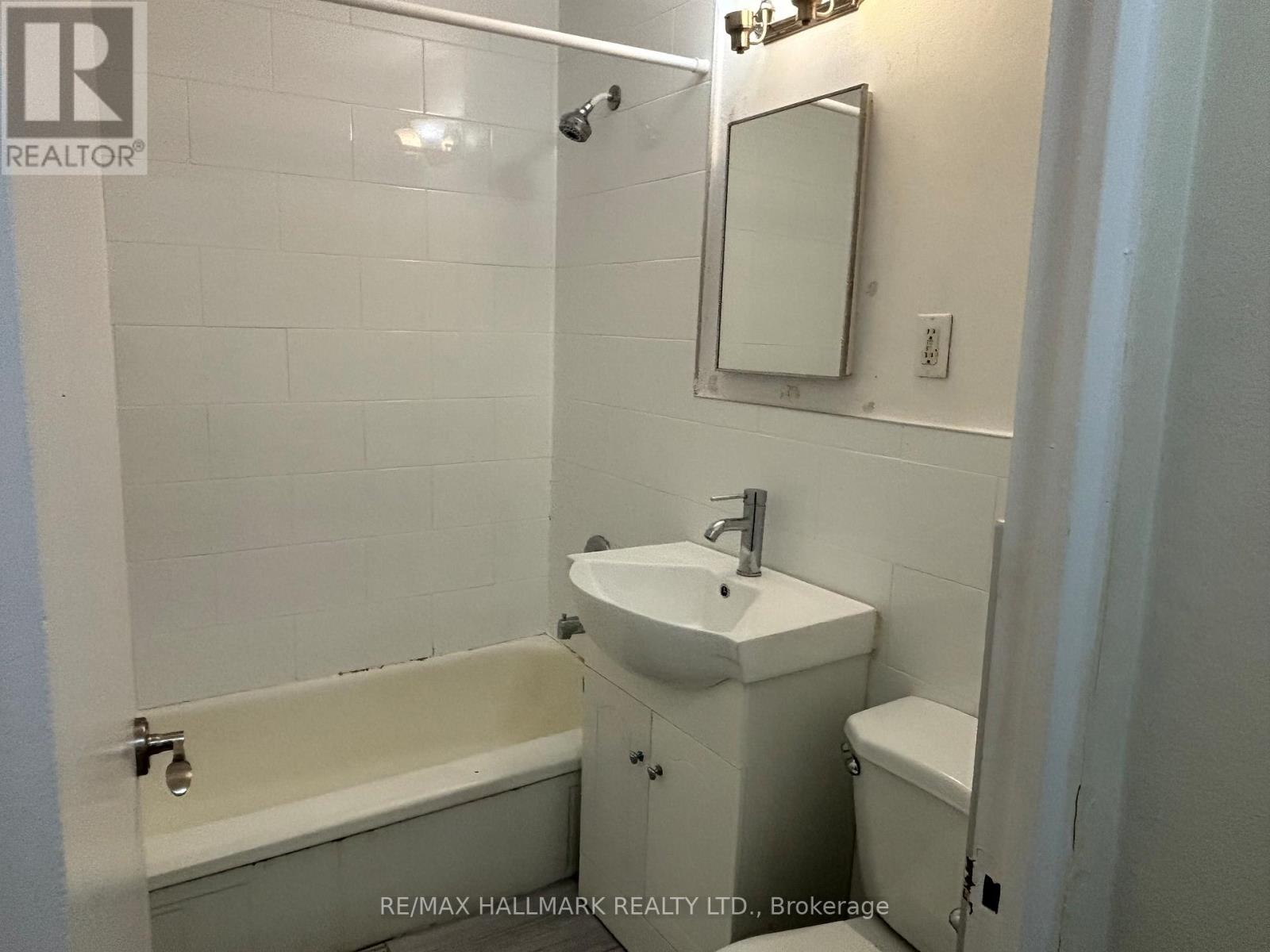 A white bathroom with a sink, toilet and bathtub.