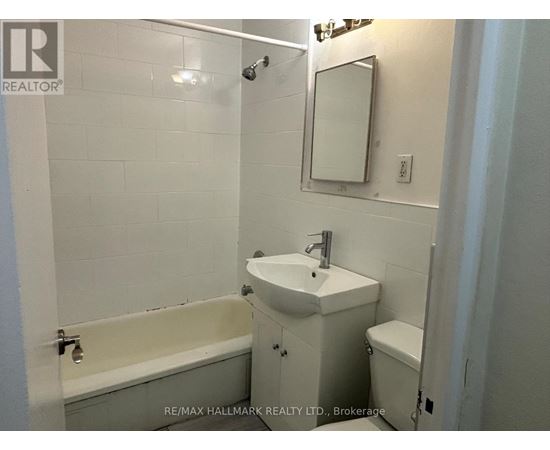 A white bathroom with a sink, toilet and bathtub.