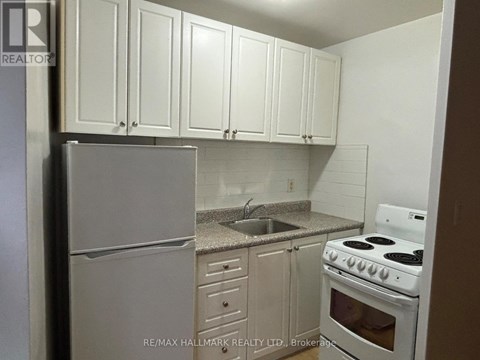 A kitchen with white cabinets and appliances.