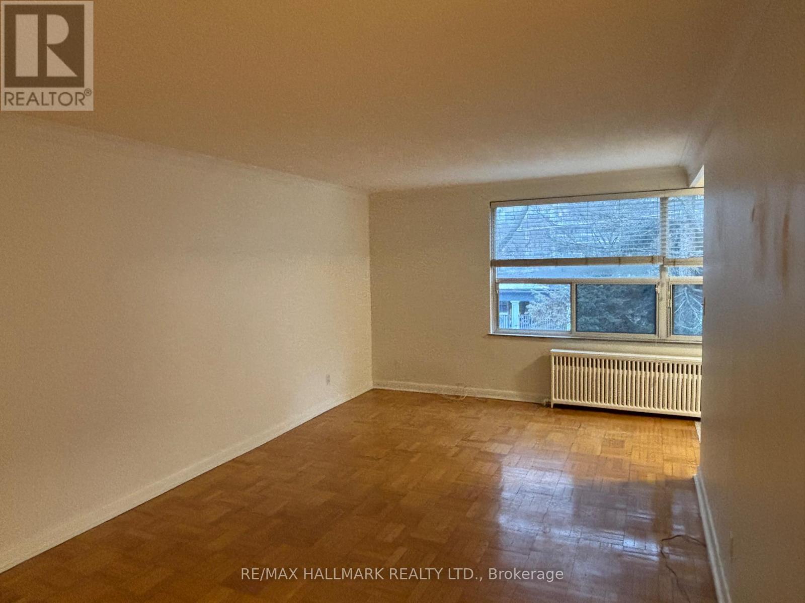 A room with a window and a radiator on the floor.
