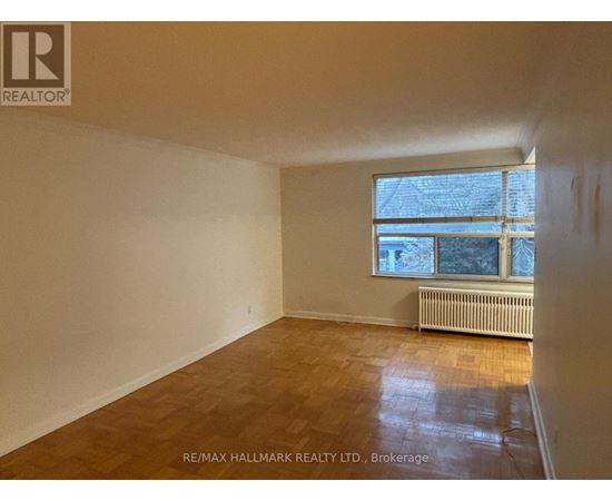 A room with a window and a radiator on the floor.