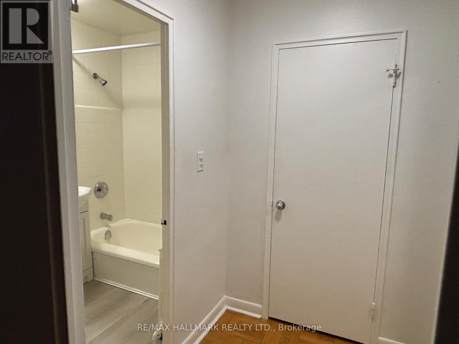 A white bathroom with a door and a bathtub.