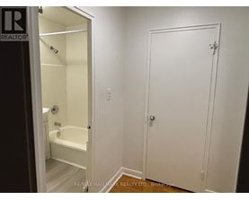 A white bathroom with a door and a bathtub.