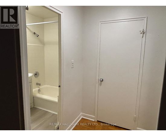 A white bathroom with a door and a bathtub.