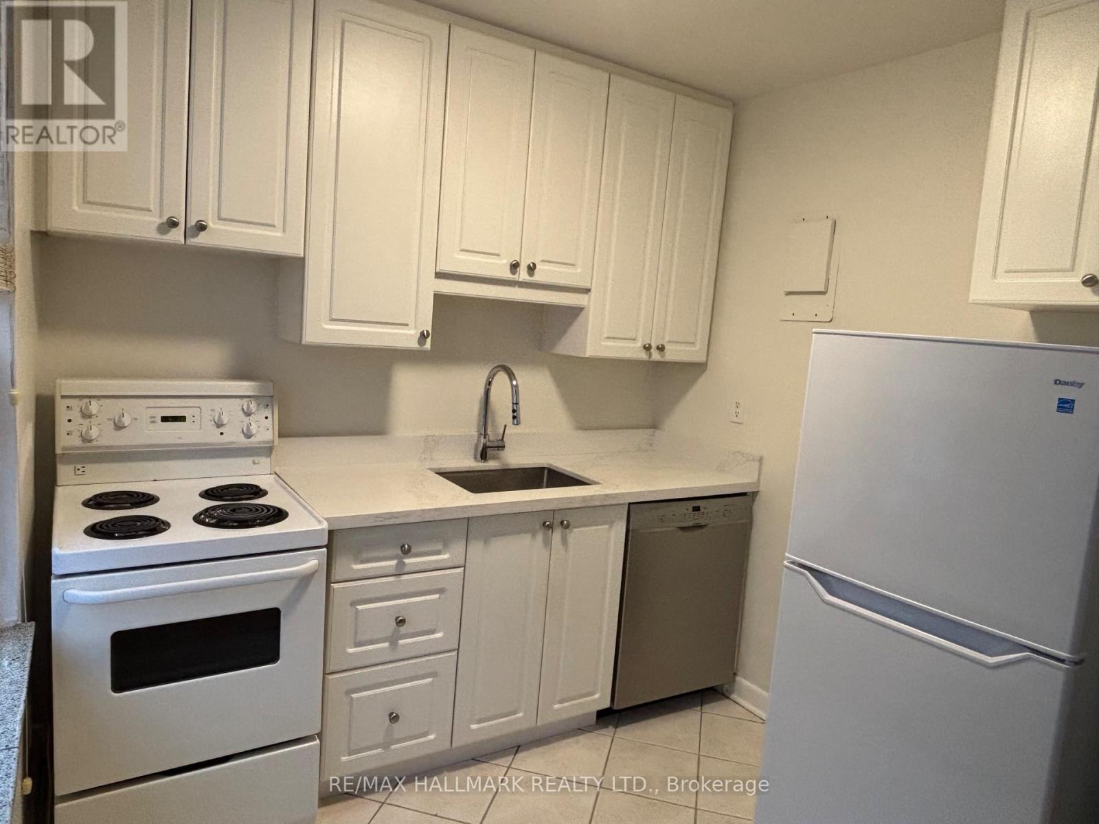 A kitchen with white cabinets and appliances.
